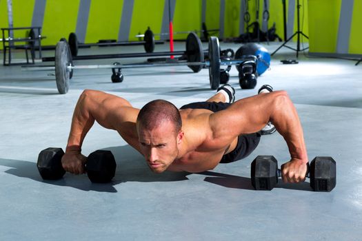 Gym man push-up strength pushup exercise with dumbbell in a crossfit workout