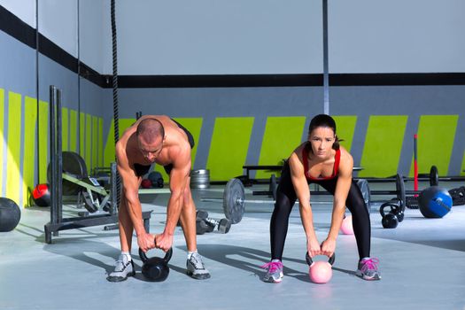 Kettlebells swing crossfit exercise man and woman workout at gym