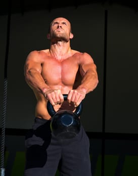 Crossfit Kettlebells swing exercise man workout at fitness gym