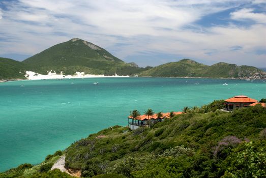 Houses in front of a crystalline turquoise sea in Arraial do Cabo, Rio de janeiro, Brazil
