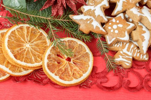christmas background with needles. orange slices and gingerbreads on red
