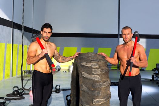 Crossfit sledge hammer men workout at gym posing to camera