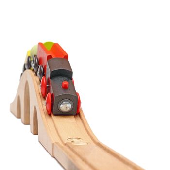 wooden train coming form a bridge isolated over white background