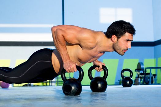 Gym man push-up strength pushup exercise with Kettlebell in a crossfit workout
