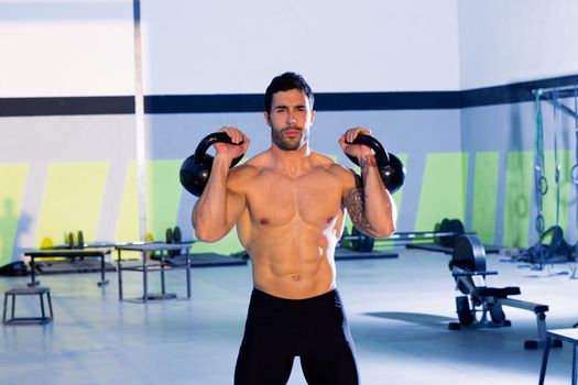 Crossfit man lifting kettlebell workout exercise at gym