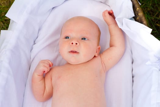 A newborn baby is looking around with his eyes open.