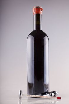 Red cap wine bottle with thermometer and other instrument