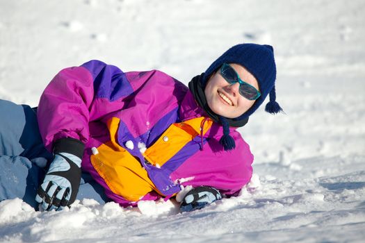 Happy skier laying in the snow