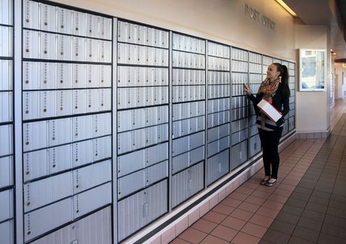 Post office mail boxes lining a wall outside