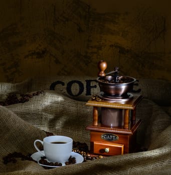 Coffee Mill with beans, cup and burlap. still life