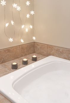 Bath with foam. Bathroom decorated with cozy lights and candles.