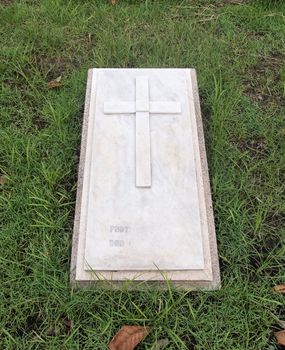gravestone with christian cross and text space at cemetery