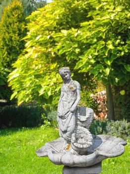 Old statue of a fountain in a shady park