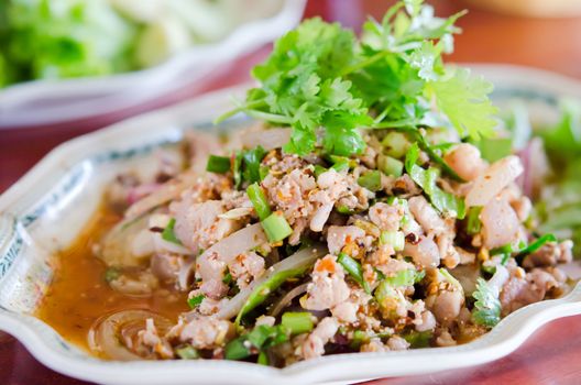 Thai style cuisine , spicy minced pork  with mix vegetable on dish 
