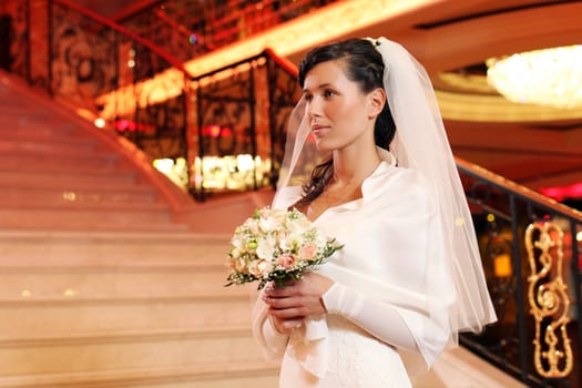 Happy bride with bouquet of beautiful flowers indoors