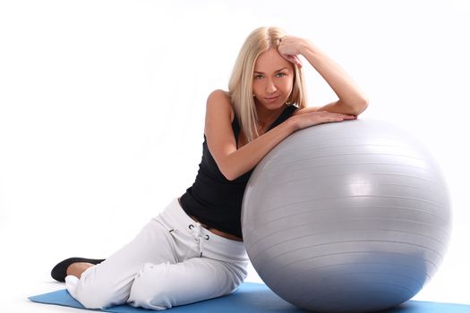 Close up of happy and beautiful woman with fitness ball isolated on a white