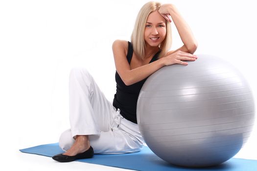 Close up of happy and beautiful woman with fitness ball isolated on a white