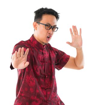 Southeast Asian Chinese man practicing kungfu, isolated on white background