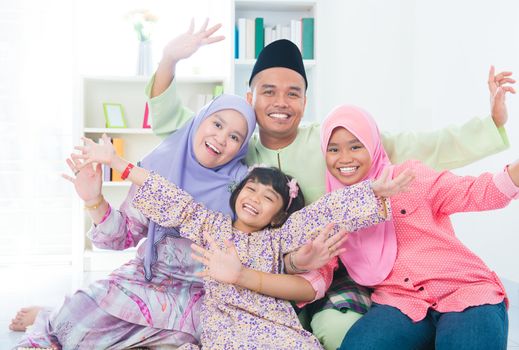 Excited Southeast Asian family at home. Muslim family living lifestyle.