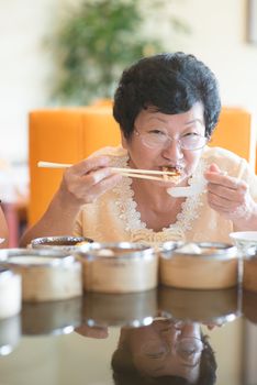 Happy 60s Senior Asian Woman dining at restaurant