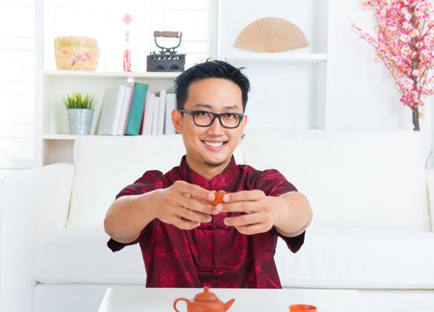 Southeast Asian Chinese man holding teacup indoors