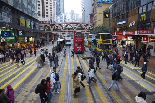 Crowds of crossing a busy road junction on Hong Kong Island in Hong Kong