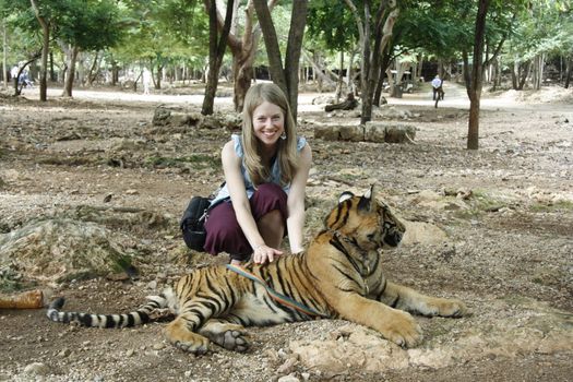 Caucasian young woman and the Tiger in a Tiger Temple, Kanchanaburi province, Thailand