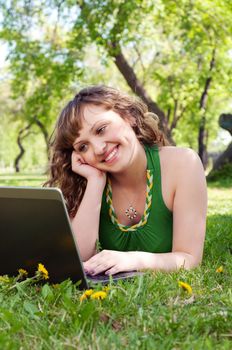 portrait of a beautiful woman, working with a laptop in a park