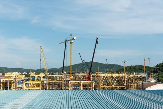 Large construction site with multiple metal cranes, taken on a sunny day