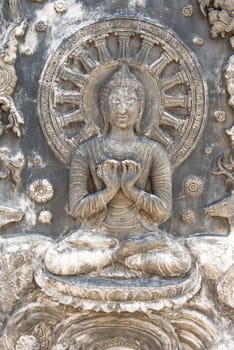 Ancient old vintage buddha sculpture on the wall, taken on a sunny day