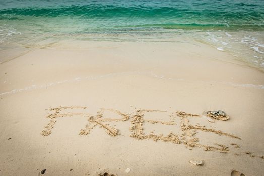 Beach on gulf of Thailand with word Free written on the sand, taken on a sunny day