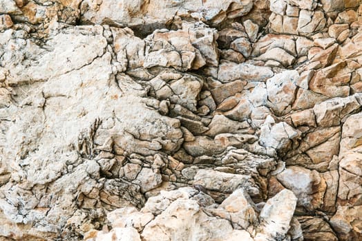 Solid limestone rock texture with muliple cracks, taken near the beach on a sunny day