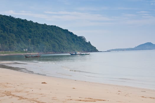 Fishing boats near the beach, which is adjacent to the mountain.
