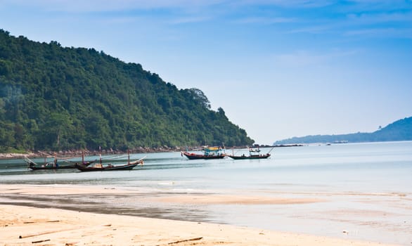 Fishing boats near the beach, which is adjacent to the mountain.