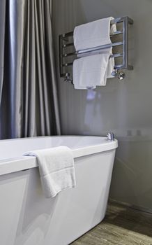 Detail of a bathroom with bathtub and towels, personal hygiene