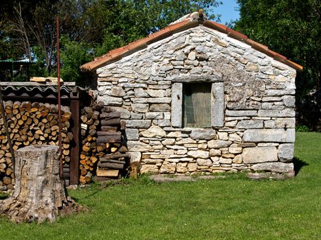 old small stone house with fire wood