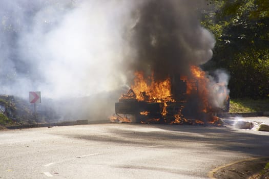 Smoke and flames billowing from a burning car