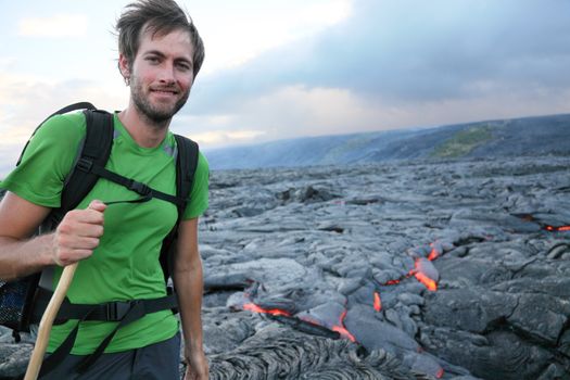 Hawaii hiker hiking by flowing lava from Kilauea volcano around Hawaii volcanoes national park, USA. Young caucasian man..