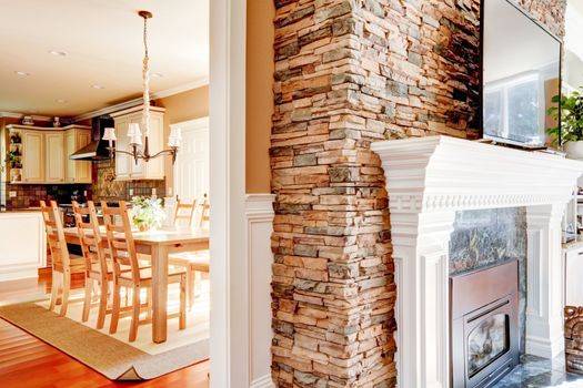 Stone fireplace with tv in theliving room and dining room and kitchen.