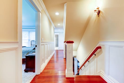 Large bright hallway with cherry hardwood and staircase.