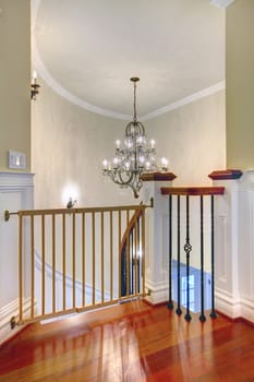 Luxury curved staircase with chandelier, cherry harwood and white trim.Child safety gates.