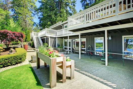 Large house back yard with two decks and flower boxes.