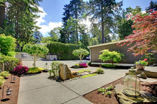 Modern front yard landscape with walkways and rocks.