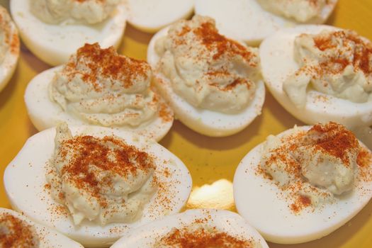 Plate of Deviled Eggs Hors D'Oeuvre sprinkled with Paprika Spice Closeup