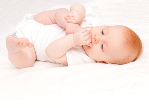 Cute Baby Girl Sucking Her Toes on White Background