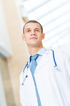 Portrait of a doctor holding papers in hand, office space