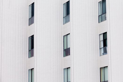 External facade of contemporary residential apartment block development with large glass windows in structured outside wall.