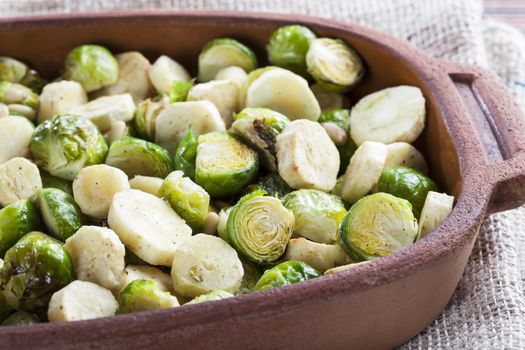 Brussels Sprouts and sliced parsnips roasted in a terracotta pan