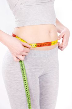 Measure tape around slim woman's waist