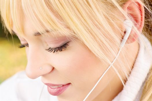 Close up of a young woman listening to music, outdoor